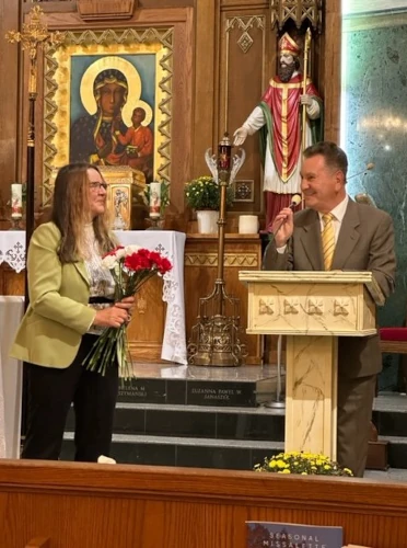 A woman presenting flowers in front of a religious icon during a church ceremony