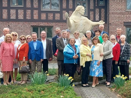 Foundation members posing together during a pilgrimage near a scenic coastline